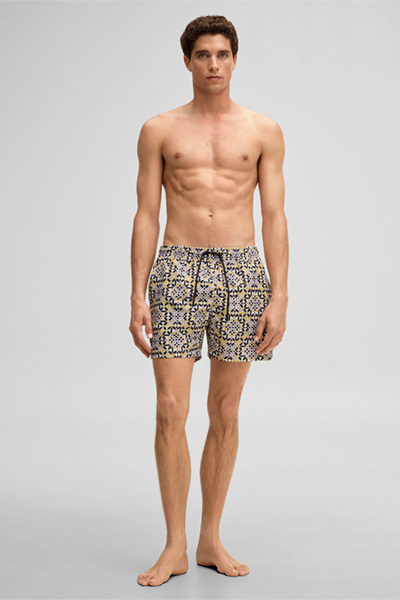 Leads to product detail page "Lago Swimming Shorts in a Mustard Yellow Pattern"